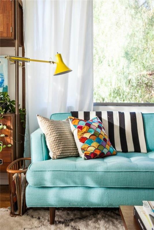 0-svetlo-modrá-sedačka-dekoratívne-vankúše-v-elegantnej-obývačke-veľké-okno