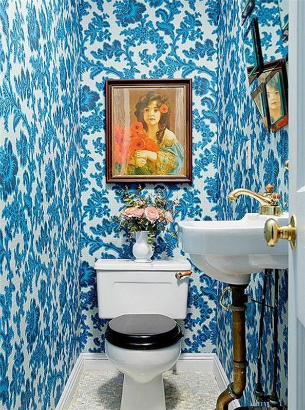 tapet trompe l'oeil i blått och vitt, i en toalett, kinesisk keramikstil, med ett porträtt av en kvinna som målar i ljusa färger, handfat i vintage -stil, toalett i viktoriansk stil