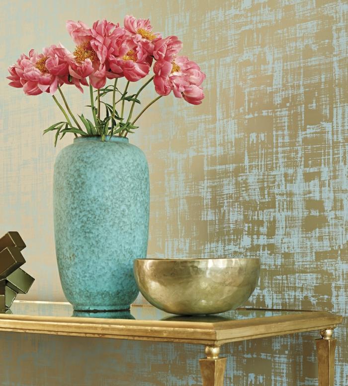 tapet trompe l'oeil blank finish i turkosblått med guld accenter, entréväggar, vas i turkos, skål i guldfärg, entrébord i guldfärgad metall och härdat glas