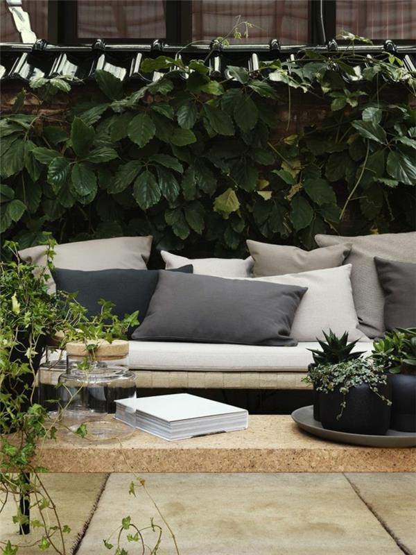 1-trädgård-soffa-kuddar-grå-och-beige-kuddar-grön-växt-trädgård-bord-i-ljust trä