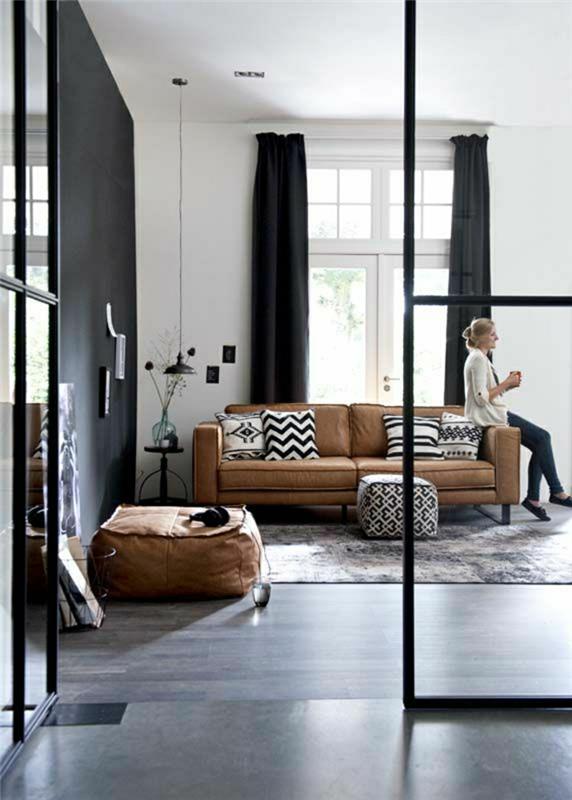 1-obývačka-v-hnedej koži-žene-čiernych závesoch-dlhé-záclony-koberec-podlaha-čierna-parketa