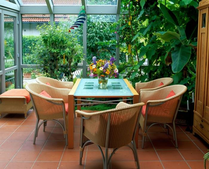 veranda-i-matsal-rotting-möbler-glas-och-trä-bord-blommig-veranda