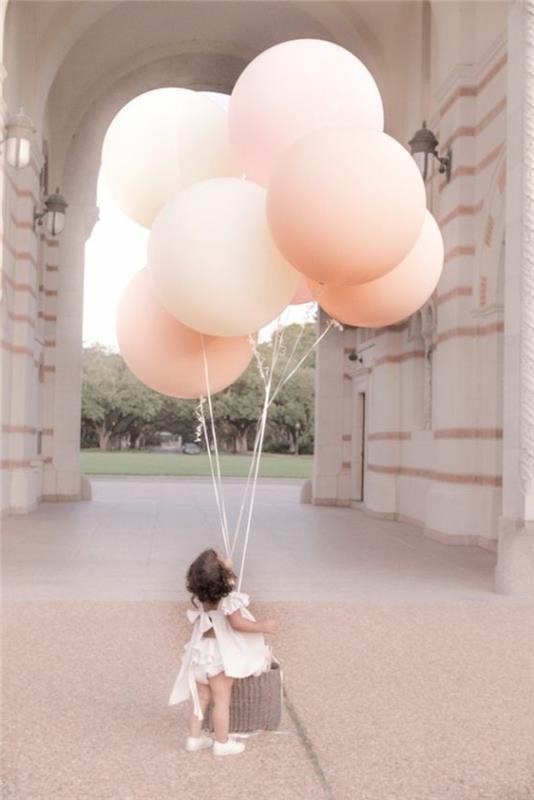 69-bukett ballonger i rosa som hålls av ett barn