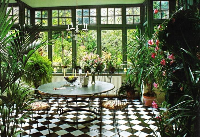 deco-veranda-möblerad-på-vintern-trädgård-interiör-veranda-nedsänkt-i-grönska-runt-bord-av-stolar