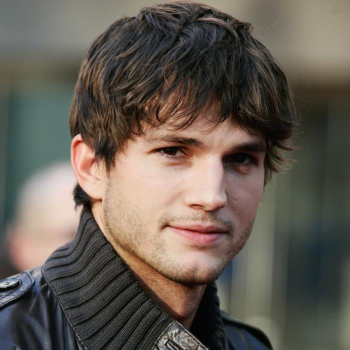 chlapčenský účes, Ashton Kutcher, sivý sveter, mierne strapaté vlasy, hnedé oči