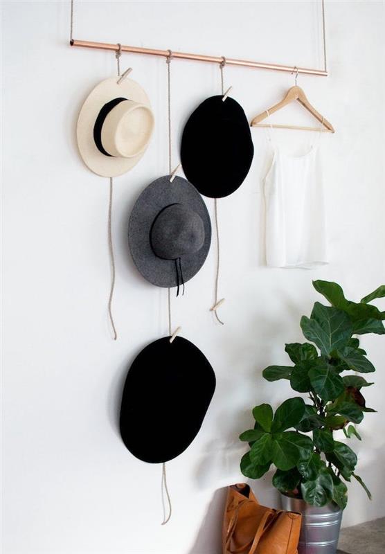 DIY sovrumsinredning i kopparrör med hattar och hängande kläder, på sladdar med klädnypor, grön växt och läderväska