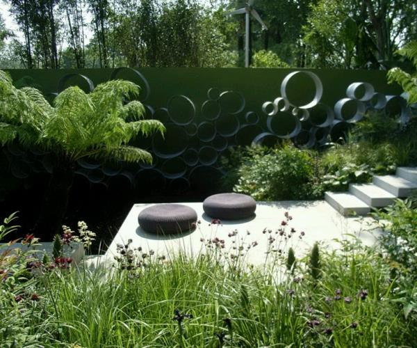 Minimalistický-dvorček-vonkajšia-záhrada-s-čerstvými-zelenými-rastlinami-zdobenie-a-dve-mäkké-zaoblené-vankúše-príslušenstvo-tiež-okrúhly vzor-stena-pre-modernú-záhradu-zmenšená veľkosť