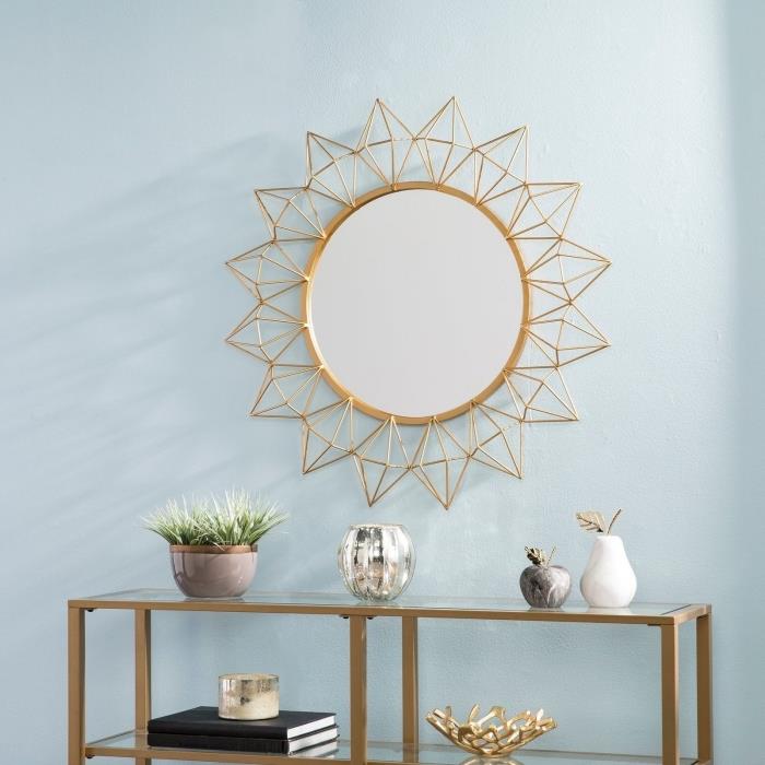 نموذج مرآة ذهبية على شكل الشمس ، ديكور غرفة المعيشة بجدران زرقاء باستيل مع أثاث وأشياء بتشطيب ذهبي