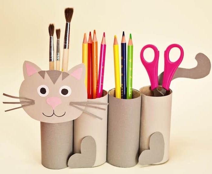 ručná činnosť 6 rokov stará s recyklovanými rolkami toaletného papiera a vzorom tváre mačky z papiera