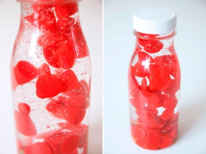 hur man gör en lavalampa -effektleksak, en sensorisk flaskaidé att göra själv, en DIY -flaska fylld med babyolja och små röda leksaker