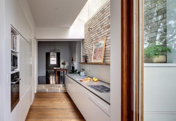 paralelne osadený model malej kuchyne, biely a drevený kuchynský dekor s tehlovou stenou a drevenou podlahou