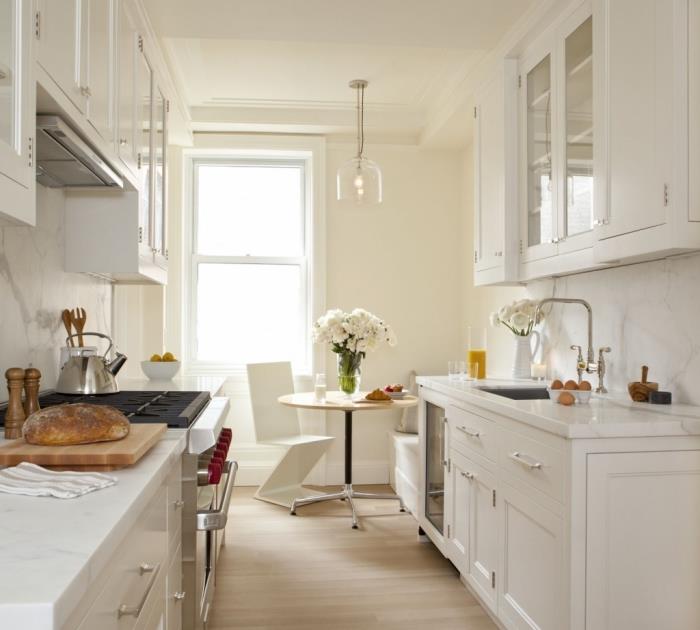 paralelný model kuchyne, príklad bielej kuchyne s bielou mramorovou stenou a podlahou zo svetlého dreva