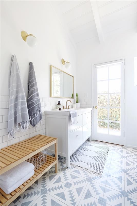 biela kúpeľňová skrinka v bielej a svetlošedej farbe s mosadznými prvkami, ktoré vyžarujú pokoj