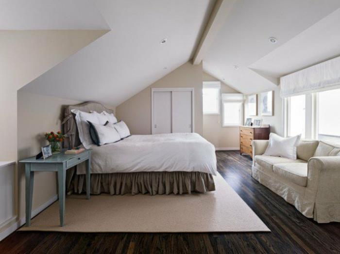 beige väggfärg, vit masardat tak, beige matta, vita och gråa sängkläder, vit soffa, vintage skrivbord, trä byrå, vindmöbler
