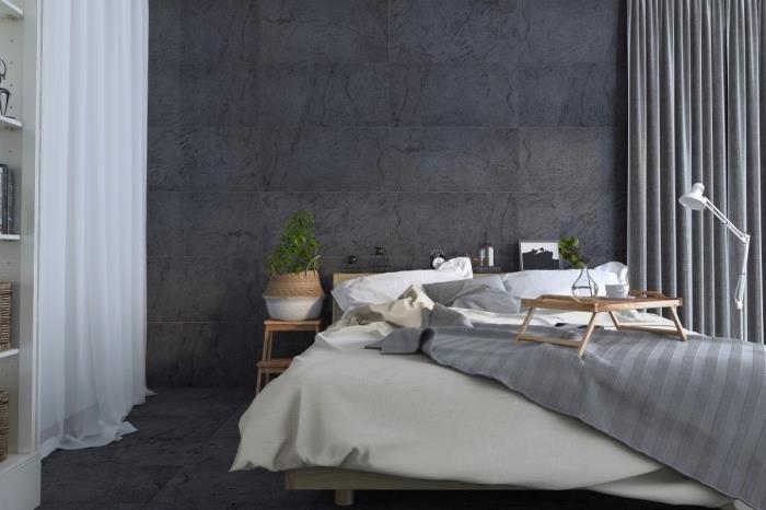 mysig atmosfär i skandinavisk anda i ett sovrum med grå väggar med vita gardiner och trämöbler
