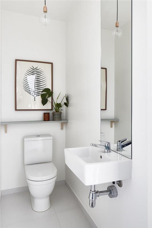 Zenová dekorácia toalety a minimalistický štýl s bielymi stenami, malým usporiadaním toalety, myšlienkou osvetlenia toalety so závesnou lampou