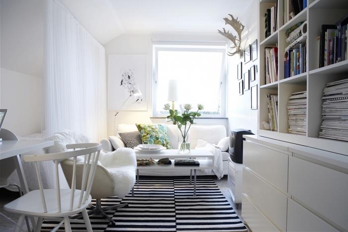 mysig atmosfär i ett litet vitt vardagsrum som drivs av en randig matta, läshörna med en mysig fåtölj utrustad med vit konstpäls