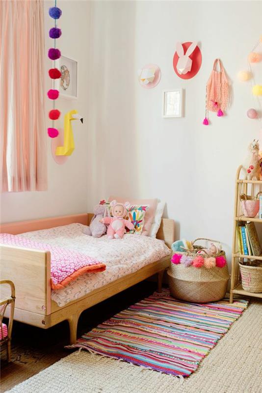 výzdoba spálne pre dospelých dekor malá spálňa v jasných farbách, s veľkými pomponmi okolo okna a nad úložnou skriňou