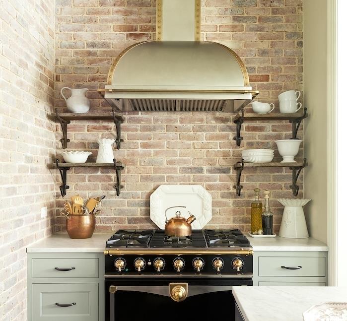 مطبخ قديم بواجهة جدار من الطوب الأخضر مطبخ خزانة سيلادون خشب ومعدن أرفف سوداء مواقد مع تفاصيل ذهبية