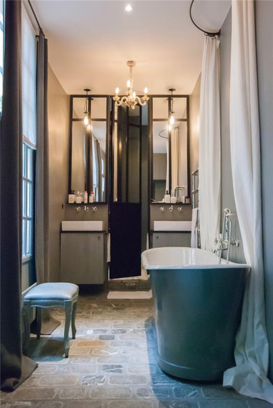 kúpeľňa v modro -bielej farbe, tyrkysová taburetka, dekoratívne zrkadlá, umývadlá s kompaktnými skrinkami, barokový luster, veľká tyrkysová vaňa