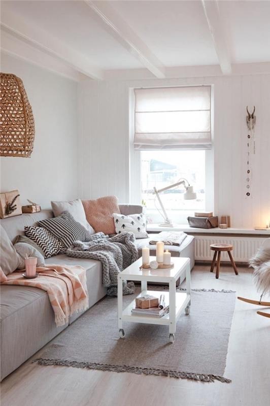 litet vardagsrum hygge deco mjukt och varmt, med en stor grå soffa täckt med dekorativa kuddar