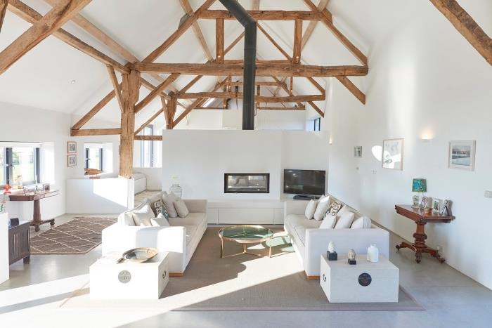 minimalistický interiérový dizajn v bielom a drevenom prevedení, myšlienka rozloženia stodoly v podkrovnej obývačke s odhalenými drevenými trámami