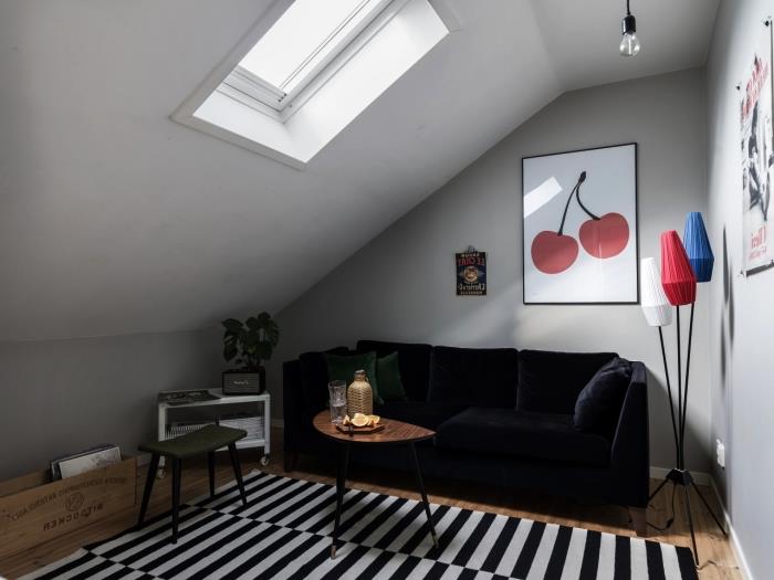 litet vardagsrum med sluttande tak i skandinavisk vintage -stil med en midnattsblå sammetsoffa och en liten möbel under sluttningen