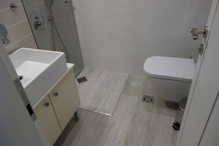 mini kúpeľňa s umývadlom a talianskou sprchou v rohu