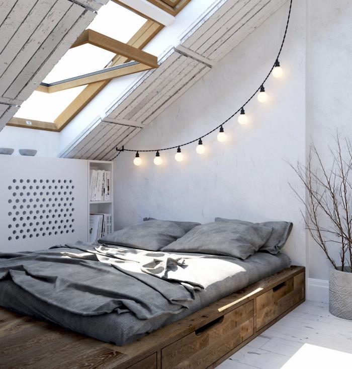 ett vindsvåning i minimalistisk stil med en låg säng med integrerade lådor och ett funktionellt sluttande skåp bredvid