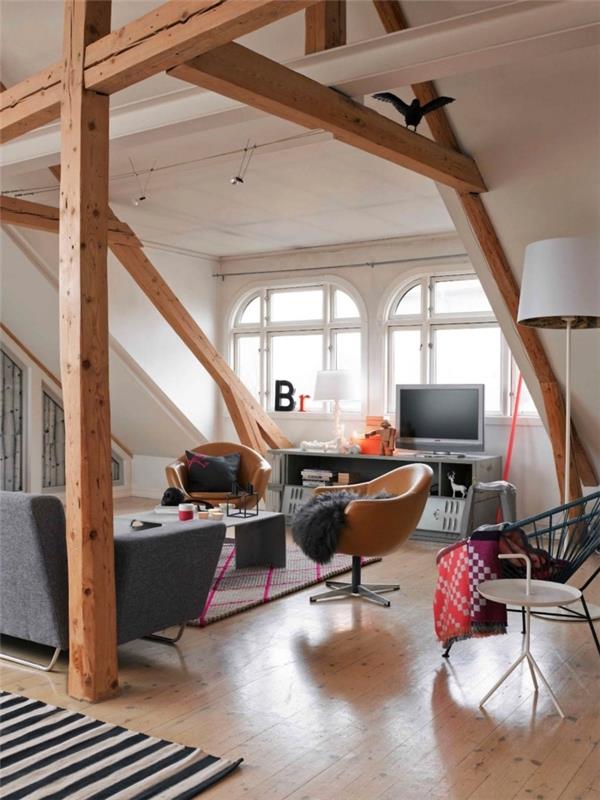 ett rymligt vindsovrum i skandinavisk vintage -stil med synliga takbjälkar som gör det möjligt att strukturera det öppna rummet