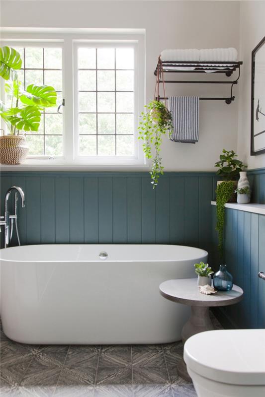liten badrumslayout med fristående badkar trendig mörkblå väggfärg