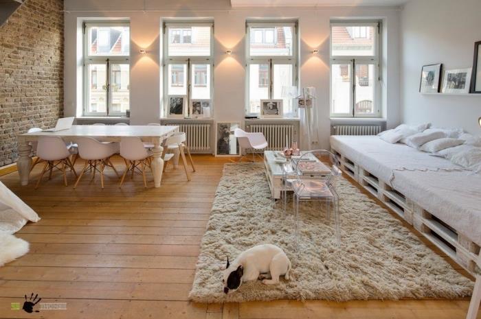 svetlý škandinávsky loft so surovými akcentmi zariadený paletovým nábytkom, ladiaci s malým paletovým konferenčným stolíkom a priehľadnou stoličkou