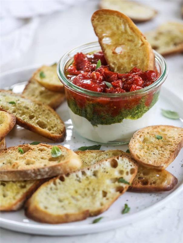 elegantné a ľahké aperitív ricota bazalkové pesto a paradajkový džem podávané s domácou bruschettou