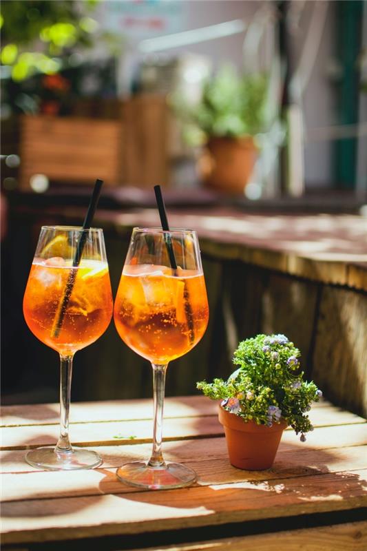 Italiensk aperitifterrass träbordskruka terrakotta isbitar apelsinskivor