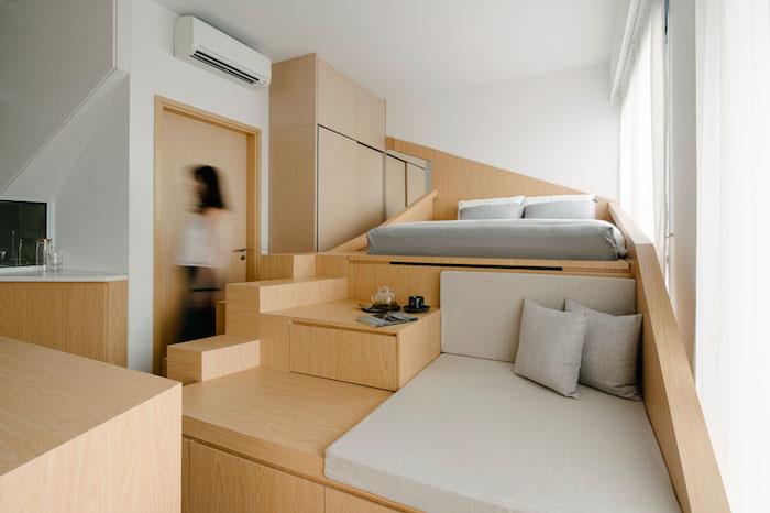 dekoration mycket liten lägenhet med säng och sittgrupp på högt träskåp, modern arkitektur inredning