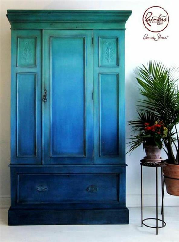 stará skrinka s novým životom, veľká skrinka, drevená skrinka namaľovaná v tieňovaných modrých a zelených farbách, čierny kovový držiak na rastlinu