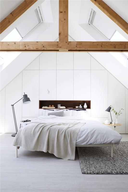 ett sluttande skåp med ett snyggt designhandtagslöst stängningssystem som upptar hela väggen i det vita sovrummet på vinden
