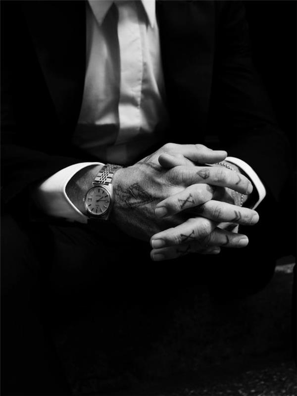 kostym och tatuering på fingrarna, en romertals tatuering