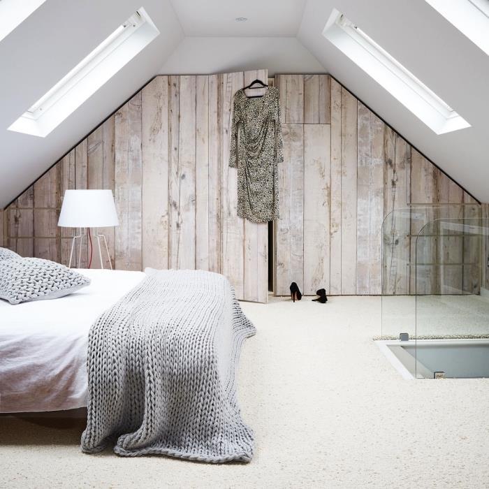 ett snyggt designat sovrum på vinden med en sluttande klädkammare med imiterade trädörrar