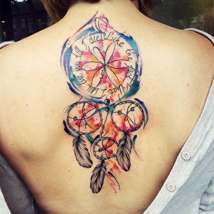 dreamcatcher -tatuering, fyra ringar i olika storlekar, mindre och en stor i blått, lila, orange, rött, citat