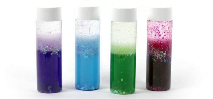 modeller av små DIY -sensoriska flaskor, med vad man ska fylla en montessori -flaska, plastbehållare med vatten och glitterfärg