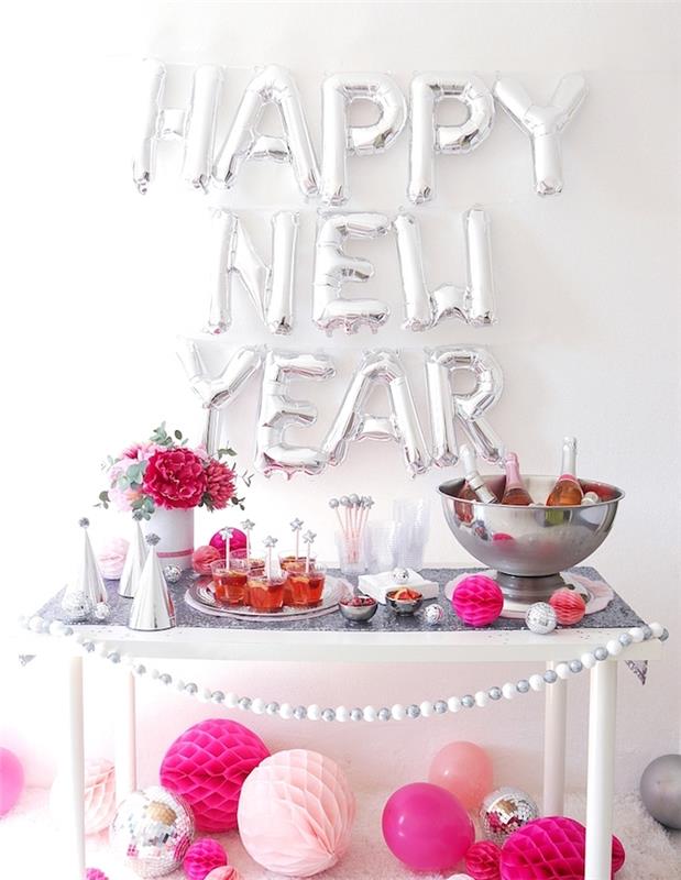 gott nytt år ballong mot en vit vägg, festgodis med partyhattar, delikatesser, krans av små bollar, dekorativa pappersbollar i olika storlekar