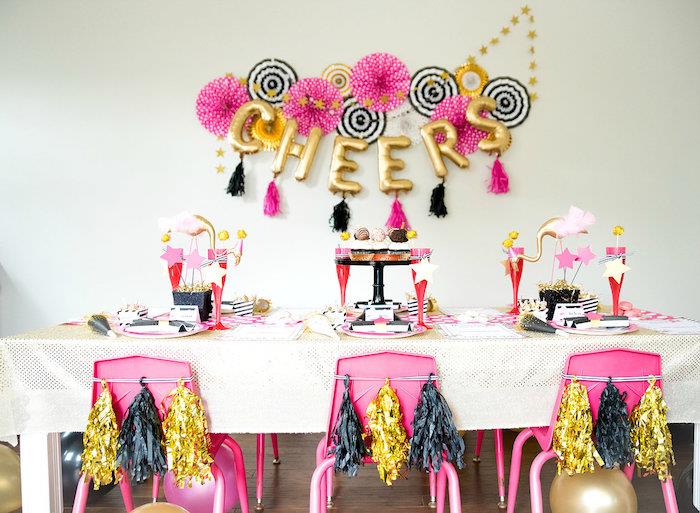 stolar dekorerade med tofsar med fransar, väggdekoration av ballonger i form av bokstäver och festliga pappersfläktar för väggdekorationen