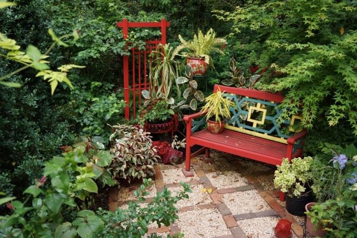 červeno maľovaný drevený záhradný nábytok, malá dekorácia vonkajšieho priestoru s lavičkou a zelenými rastlinami, záhrada potešenia