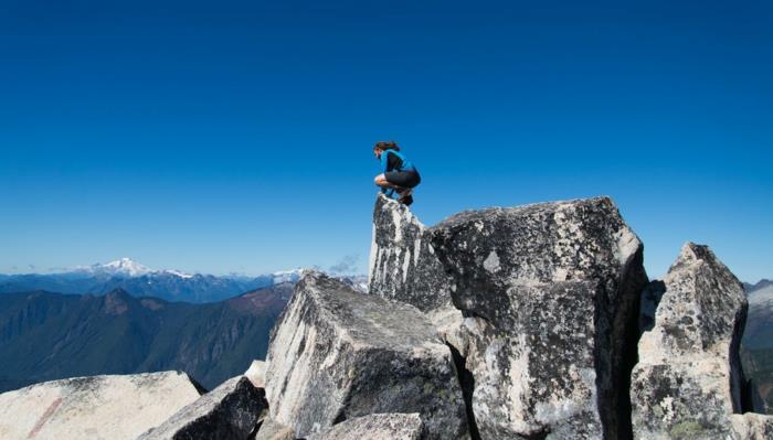 vackert landskap, landskapstapeter, sportig man på toppen av en sten i vitt och svart, molnfri blå himmel, magnifik utsikt ovanifrån på berget