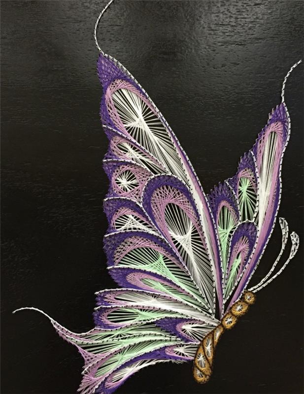 kreativa hobbyer med en teknik för att göra vackra skapelser i garn, 3D fjärilsmodell på svart träskiva