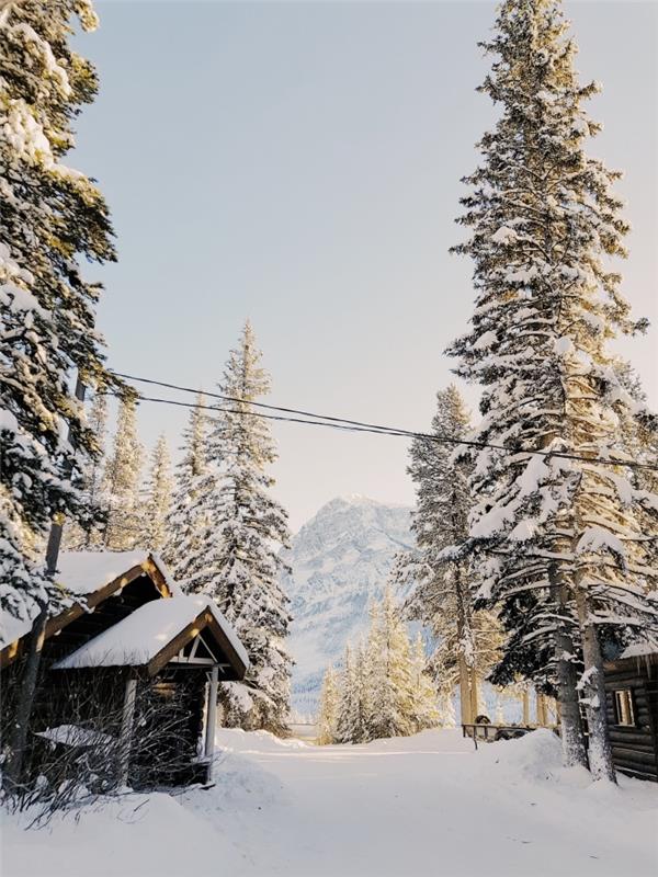 iphone tapeter för jul med ett snöigt naturlandskap i en by i hjärtat av bergen med små trähus
