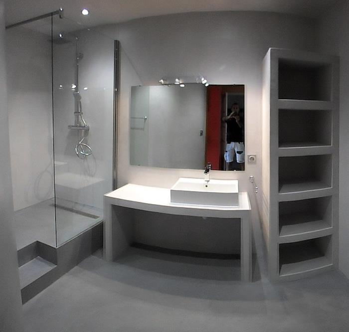 kúpeľňa s podlahou a talianskou sprchou a poličkou zo sivého voskovaného betónu v modernom štýle tvrdá