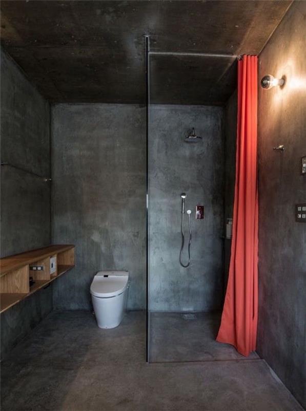 حمام صغير مغلق مع أسمنت رمادي داكن يغطي الجدران الأرضية مع دش إيطالي في كتلة واحدة