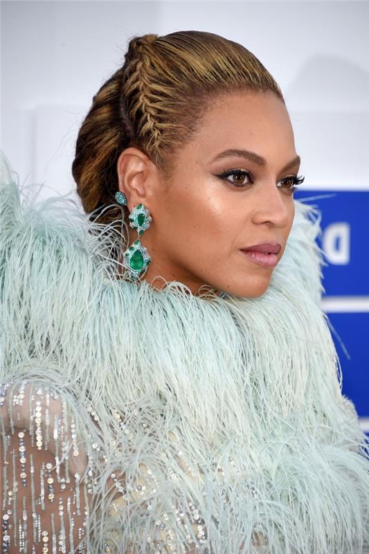 moderný a originálny účes Beyoncé s dlhými vlasmi zopnutými v drdole s korunou z malého vrkočového vrkoča, na boku vrkoč